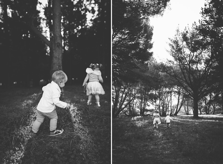 brother and sister running in pine trees
