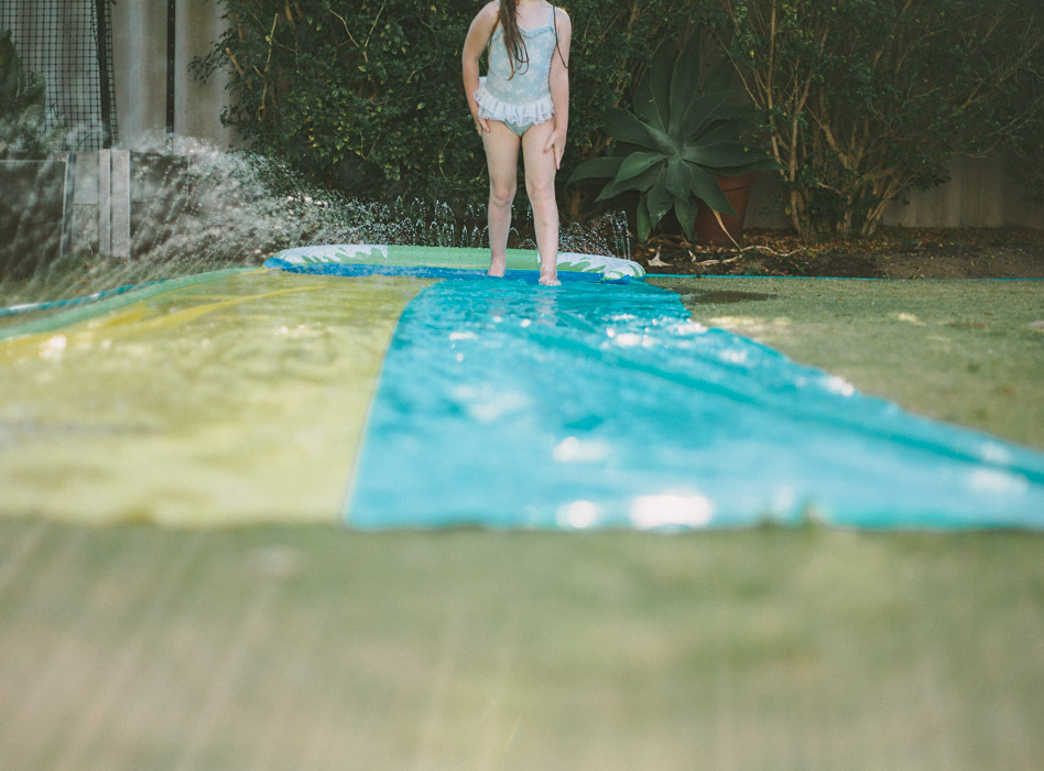 perth family photographer girl on slip n slide