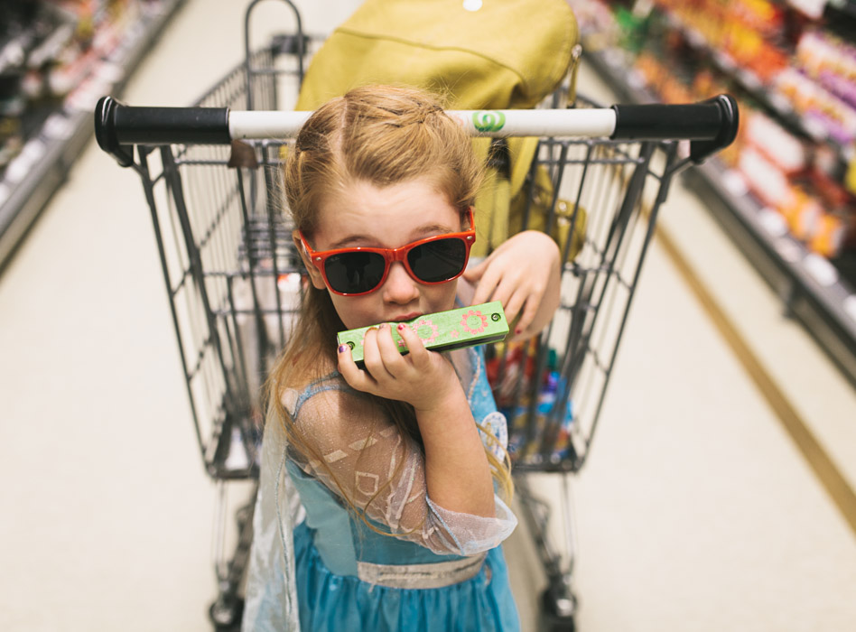 girl playing harmonica in front of trolley