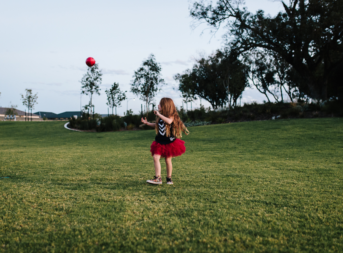 kid kicking football in dockers jumper and tutu