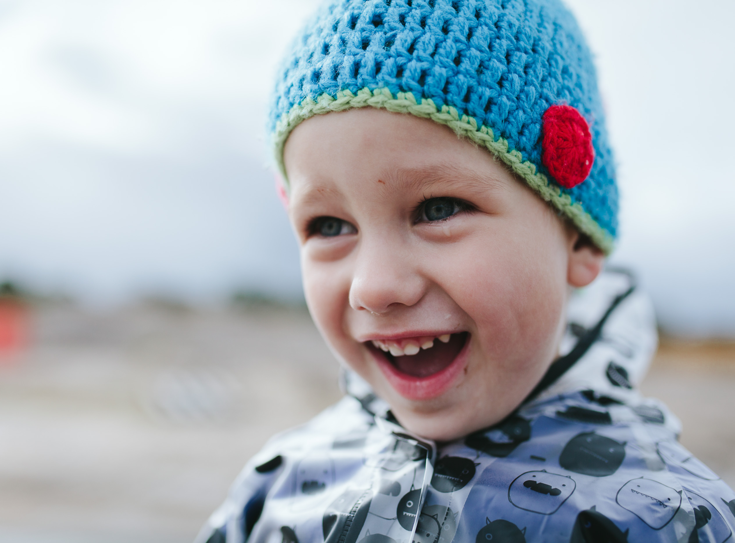 close up of boy in dinosaur beanie