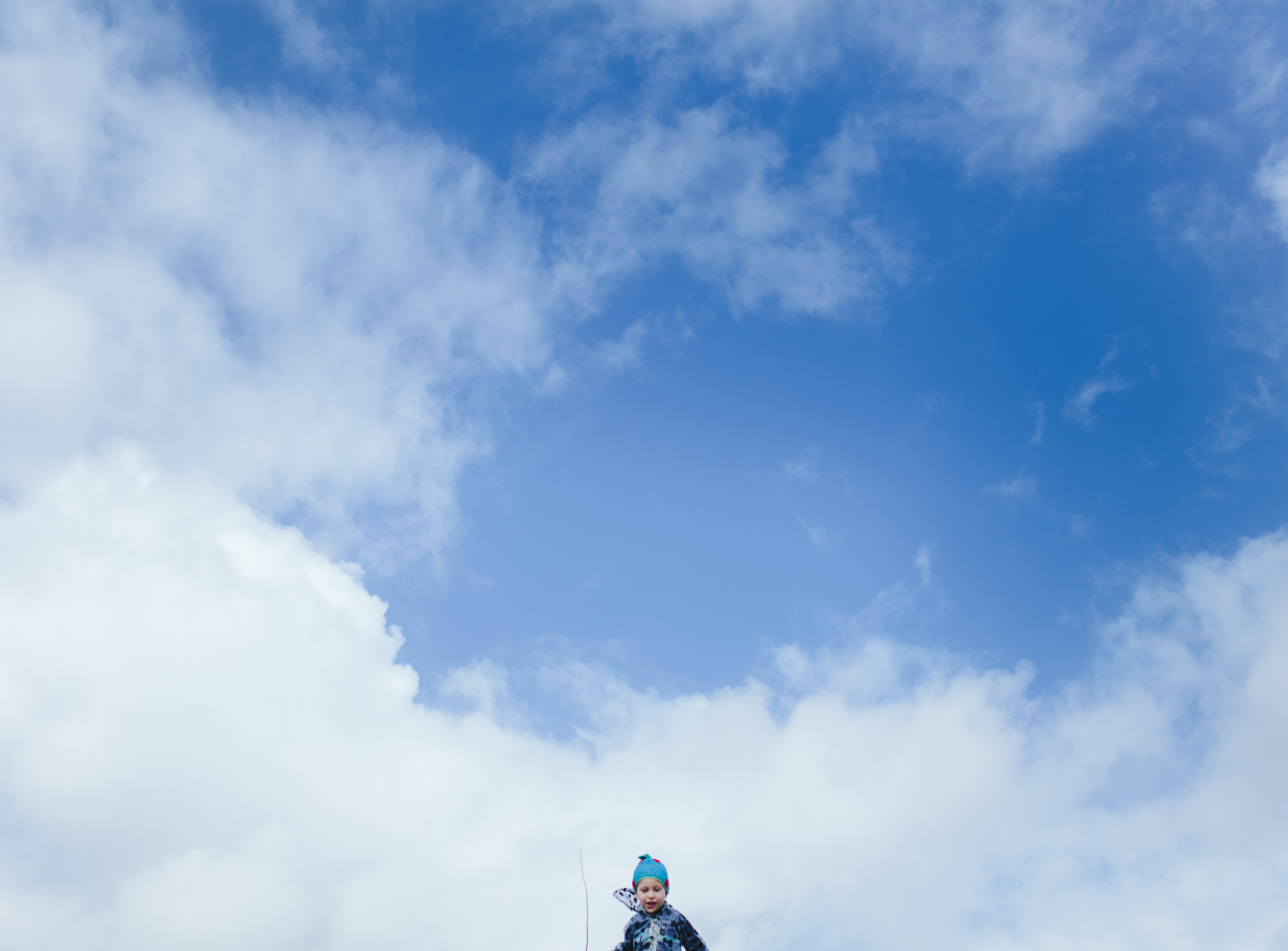 boy in clouds at top of sand hill