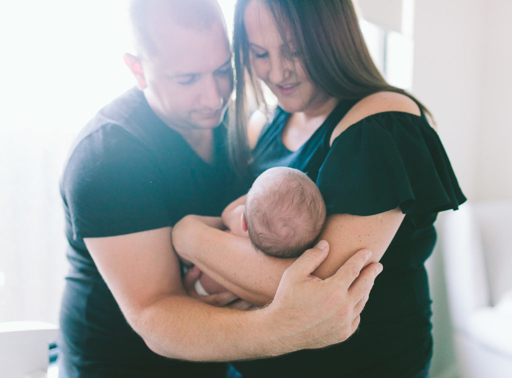 mother and father cradle baby