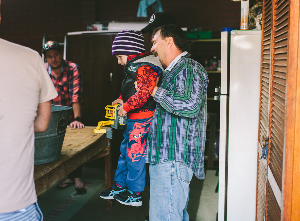 nonno lifting boy up to see sausage meat