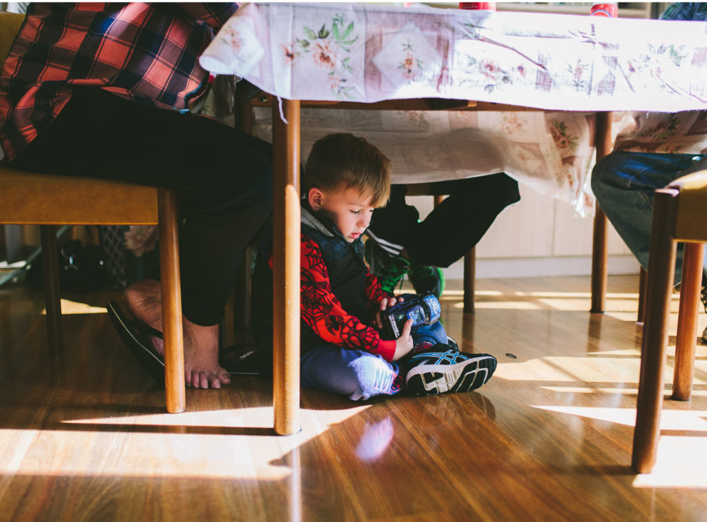 boy falls asleep under table