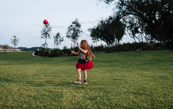 kid kicking football in dockers jumper and tutu